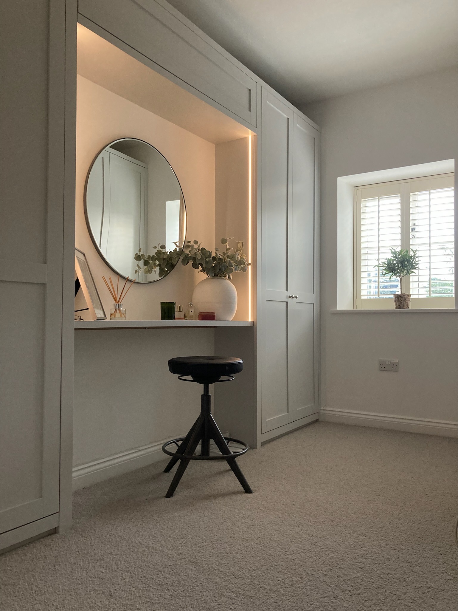 Fitted dressing room cabinetry with illuminated mirror