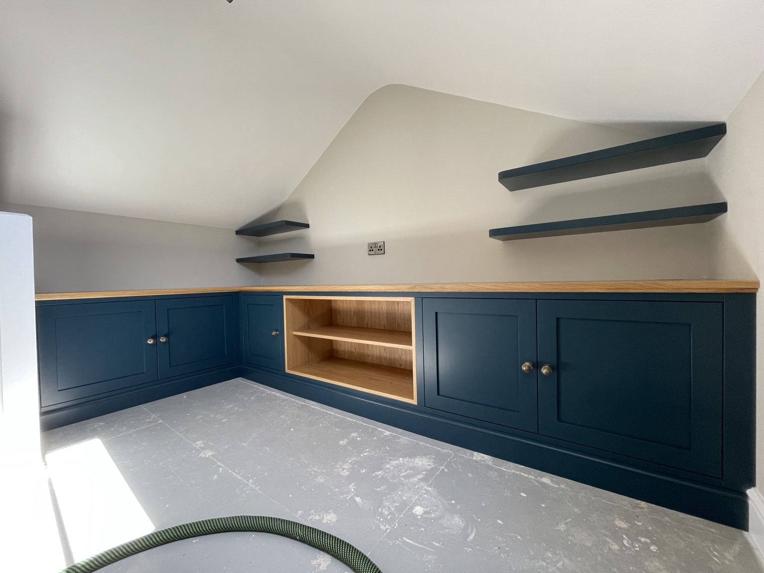 Deep blue fitted cabinetry with oak worktop and open shelving