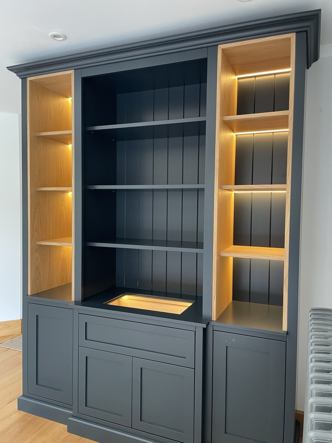 Dark painted display dresser with illuminated oak shelving