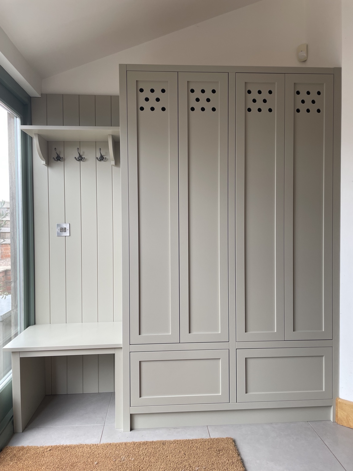 Painted fitted boot room storage with bench and coat hooks